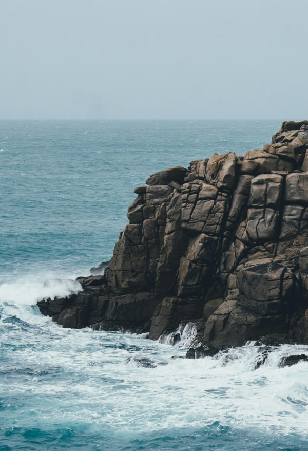 A tiny rock island surrounded by waves